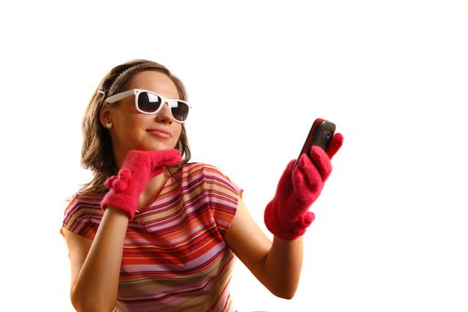 Modern looking young woman wearing sun glasses, looking at the phone