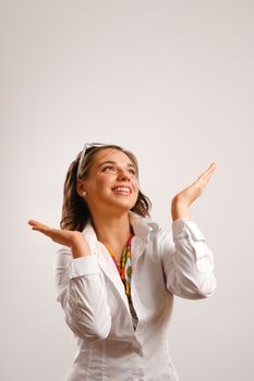 Attractive young woman wearing white jacket looking up