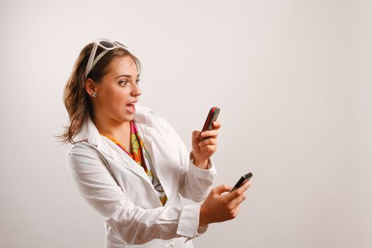 Attractive young woman wearing white jacket looking at the cellphone