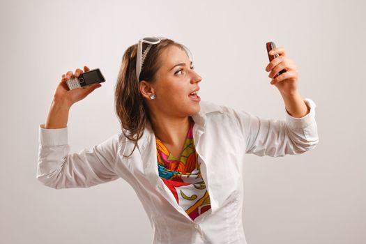 Attractive young woman wearing white jacket looking at the cellphone