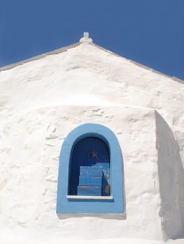 White wall of a greek church on blue sky background                            