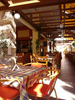 Cover terrace of greek taverna with chairs and tables                              