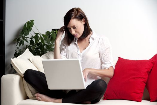 Woman sat on sofa with laptop