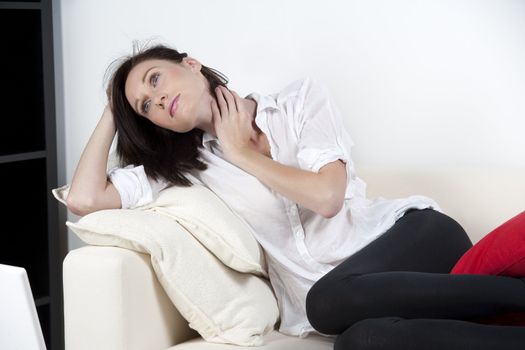 Woman resting on sofa at home in casual wear