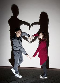 Asian couple on street making a heart