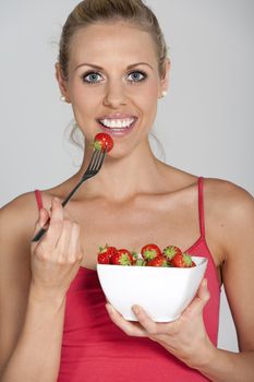 Beautiful young woman eating fresh summer berries