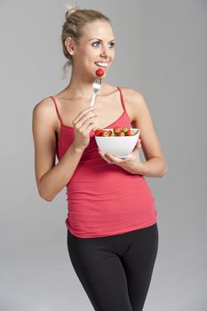 Beautiful young woman eating fresh summer berries