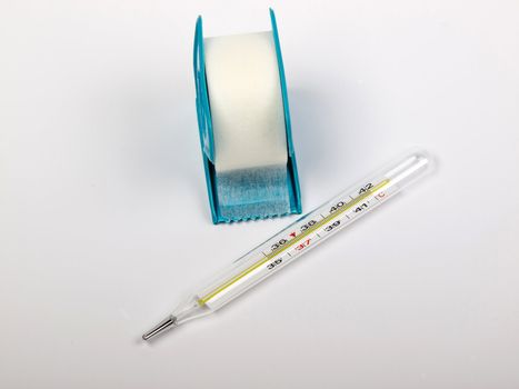 thermometer and the white adhesive bandage