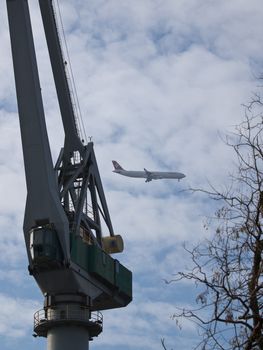 crane and the airplane on cloudy sky