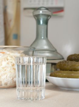 Wine-glass of vodka pickles and sauerkraut close up.