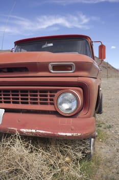 an old rusty pickup truck in the desert. Blue skies and tumbleweeds. 