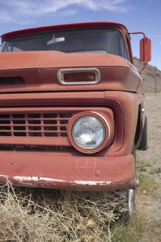 an old rusty pickup truck in the desert. Blue skies and tumbleweeds. 