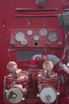 controls on the side of a fire engine with gauges