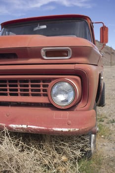 an old rusty pickup truck in the desert. Blue skies and tumbleweeds. 