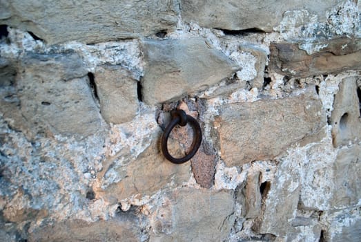 Old brick brown wall with iron ring for chains