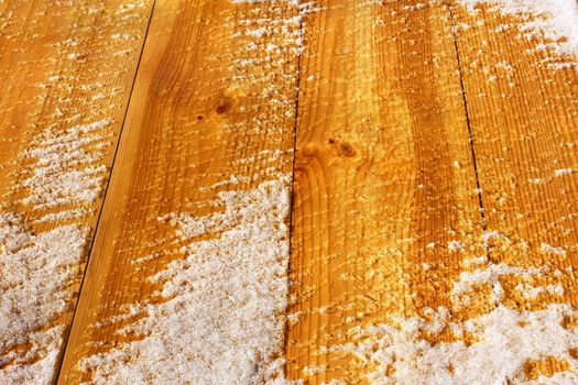 The wooden shield with new lacquered planks covered with snow