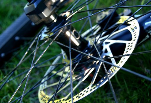 Extreme closeup of a bike wheel with spikes and brake disc