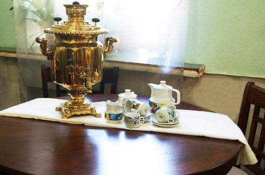 Vintage copper tea pot and tea things on the table