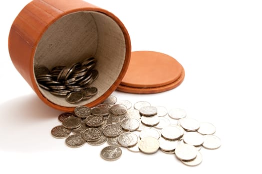 leather bowl and coins on a white background