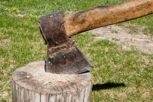 An axe in a wood trunk 
