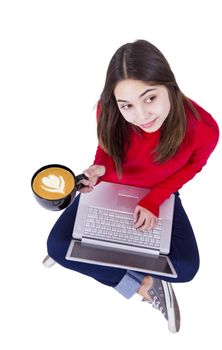 Teenager gorl is holding her  Froth Art  latte coffee and laptop on the floor.