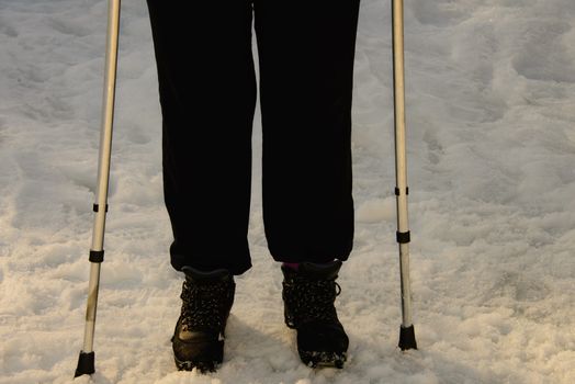 Obese person with crutches walking outdoor in the snow