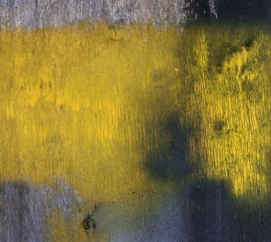 old wall of plywood is stained with yellow paint