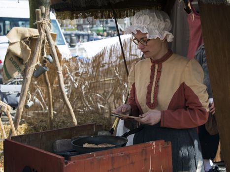 BRIELLE,HOLLAND APRIL 01:Woman in traditional costume making pancakes on the market on April 01, 2013 in Brielle,Holland.This is the party of the point in the uprising of Low Countries against Spain in the 80 Years' War
