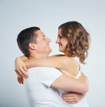 Happy beautiful young couple in love in white casual clothing. In the studio