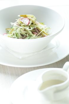Fresh and tasty salad in white dish