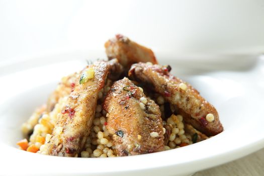 Peaces of meat with millet in the white dish