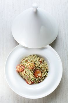 Millet in the white dish on wooden table