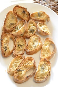 Garlic bread with herbs, on white bread dish