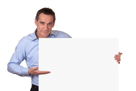 Attractive Middle Age Man in Blue Shirt Pointing to Blank White Sign with Copy Space on Right Isolated
