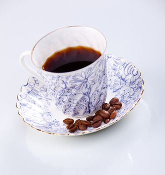 close up of a coffee cup with coffe beans