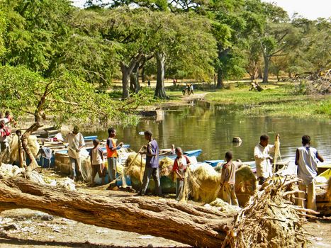 Local fishermen washing by the shore of the lake after the end of their long fishing day