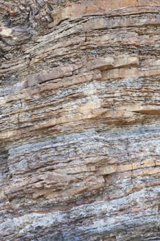 Layered rock on high steep sea bank