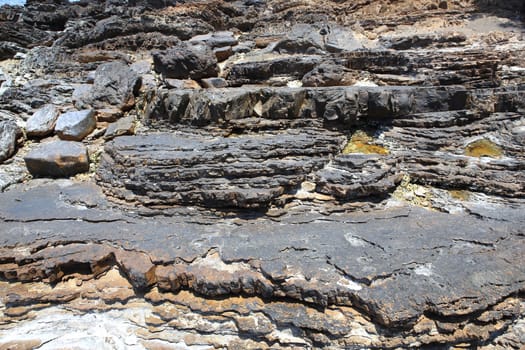 Layered rock on high steep sea bank