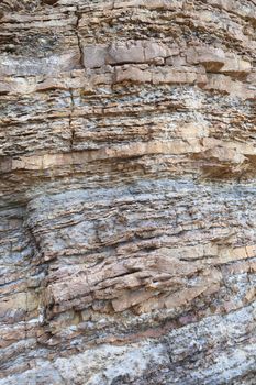 Layered rock on high steep sea bank