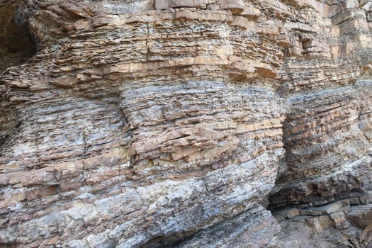 Layered rock on high steep sea bank