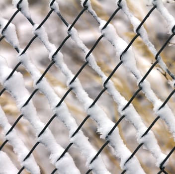 White snow frozen on chainlink fence