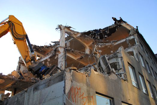 An excavator demolishing a building.