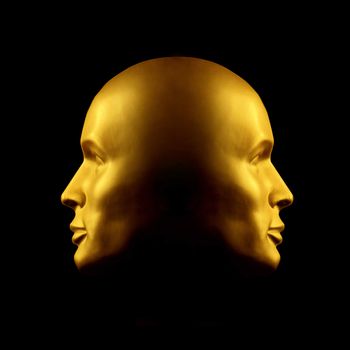 Two faced gold head statue against black