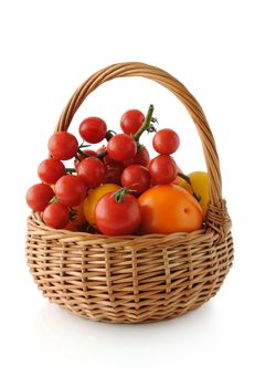 Different varieties of tomatoes in a basket on a white background