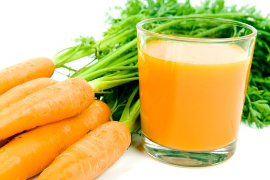 Fresh and ripe bunch of orange carrots with juice glass isolated on white background