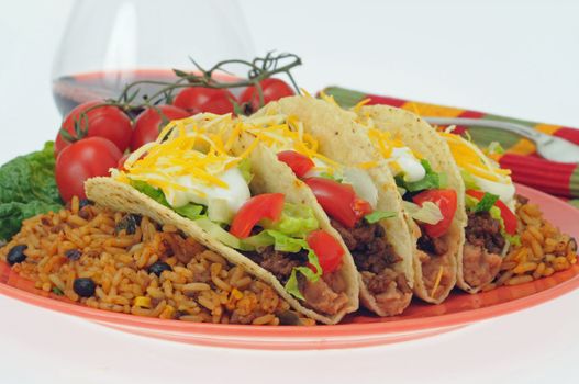 Taco meal served with mexican style rice and vegetables.