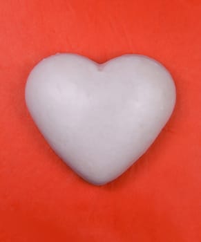 White heart (ginger cake) on red background.