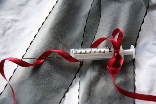 The syringe is wound by a red ribbon