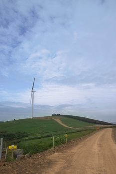 dirt road to a windmill on lush irish countryside landscape in glenough county tipperary ireland