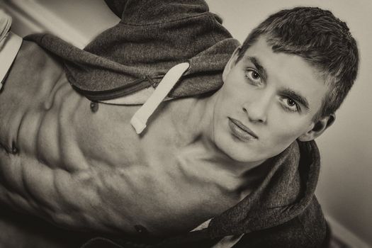 Young muscular man sitting on the floor.